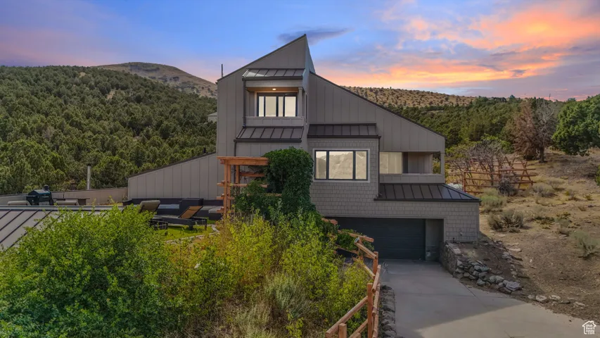 Modern home with a standing seam roof, a metal roof, and a balcony