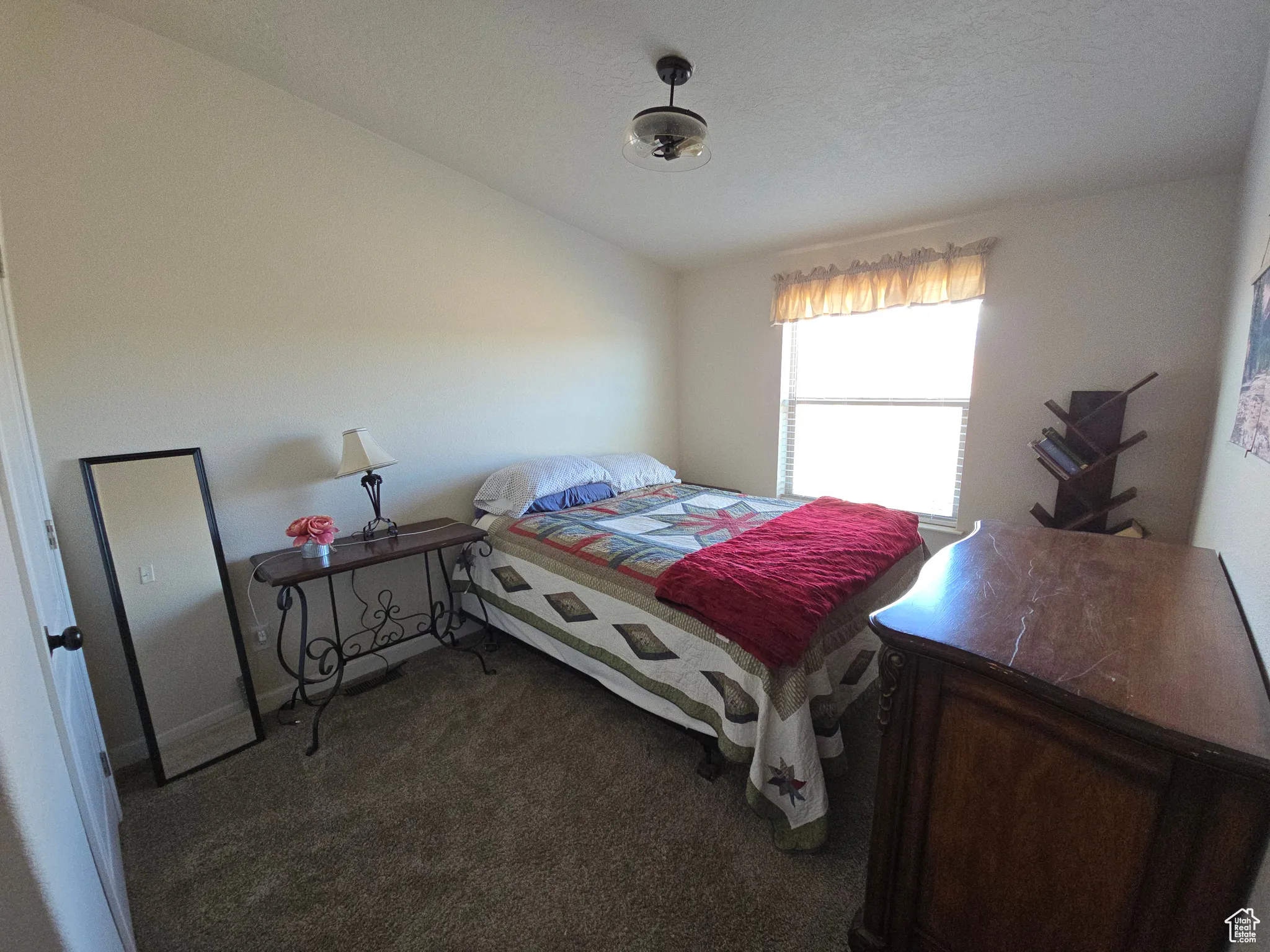 Bedroom with dark colored carpet and vaulted ceiling
