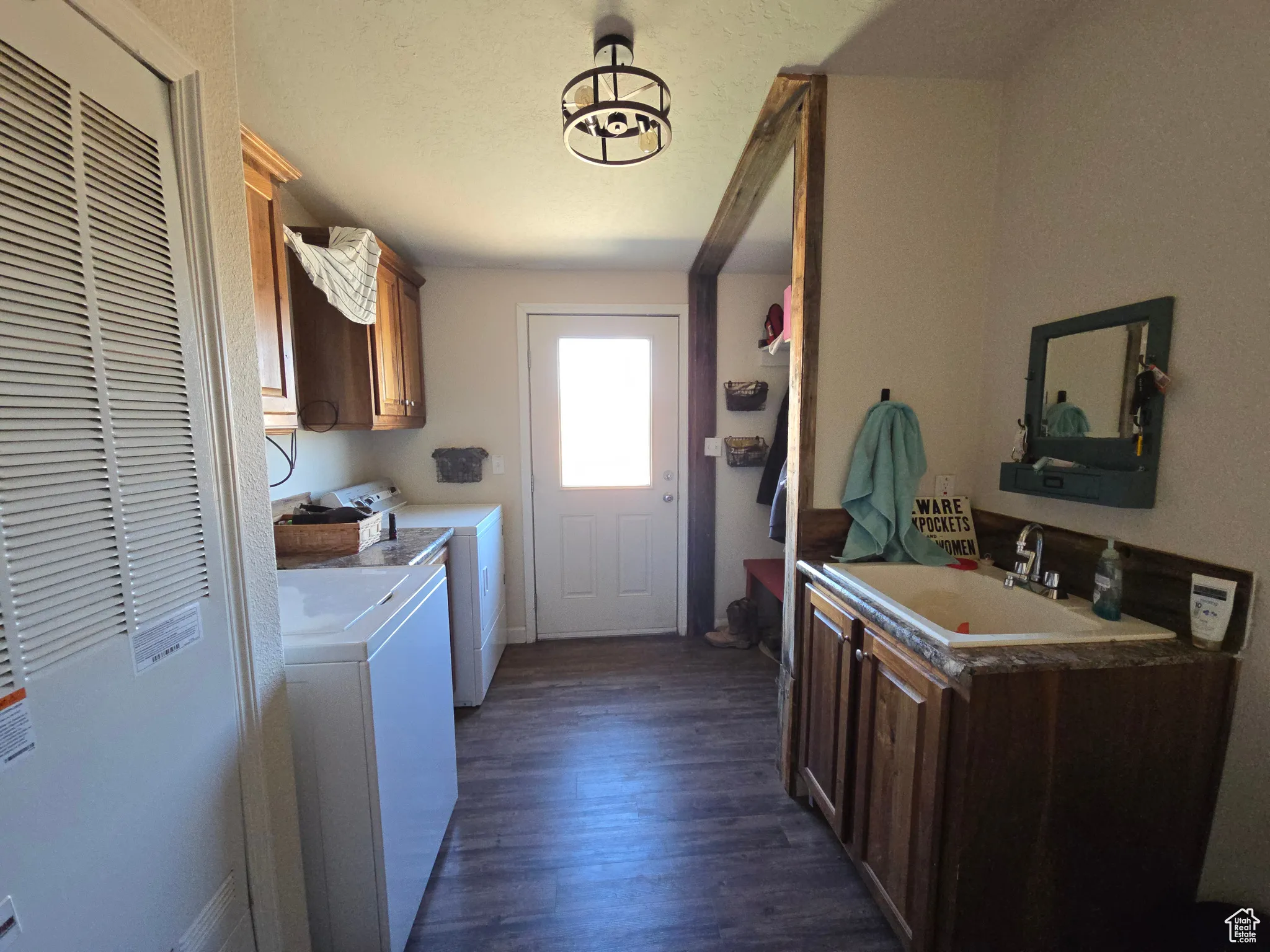 Laundry room with cabinet space, a heating unit, separate washer and dryer, and dark wood finished floors