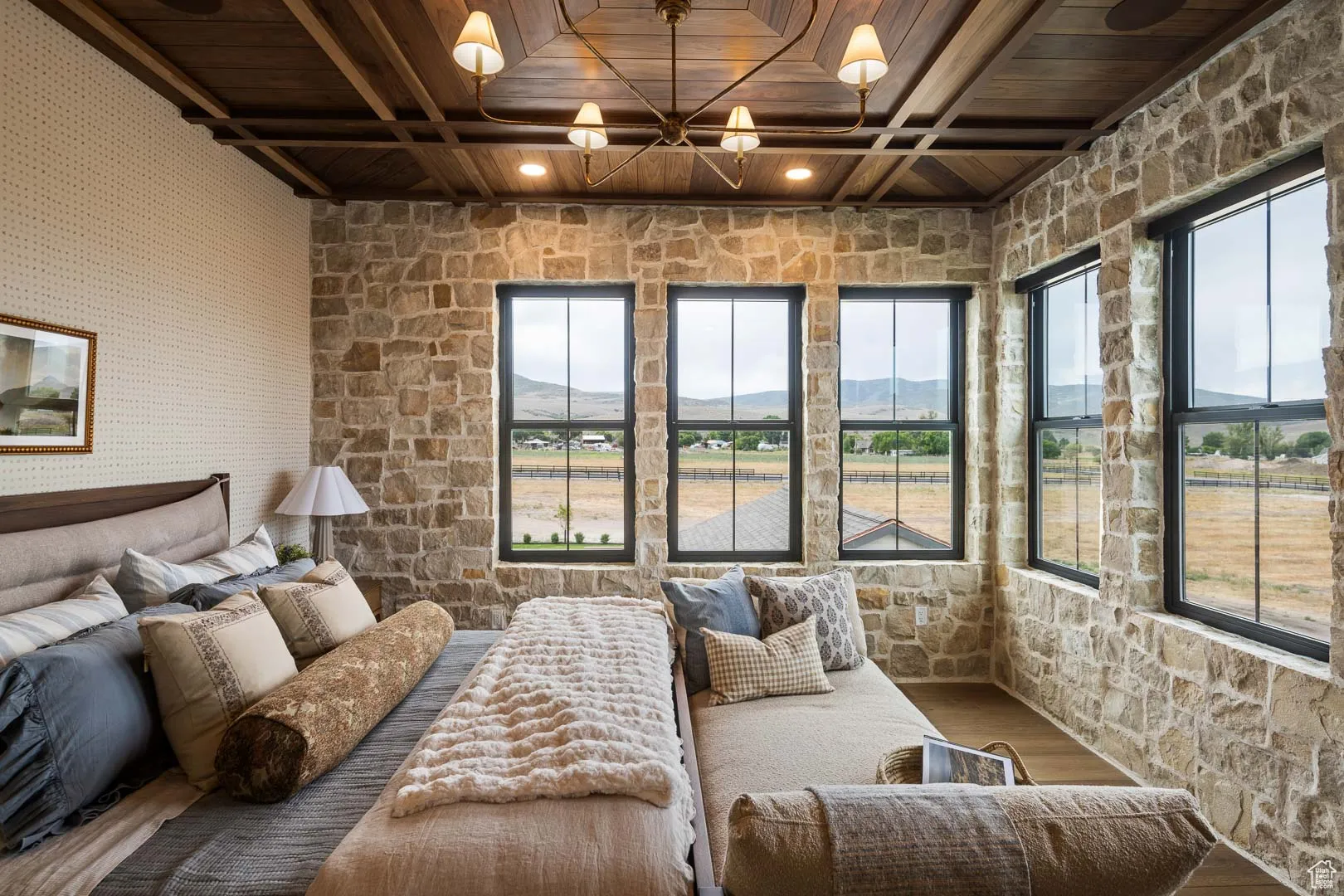 Bedroom with a wooden ceiling with exposed beams, wood finished floors, and a chandelier