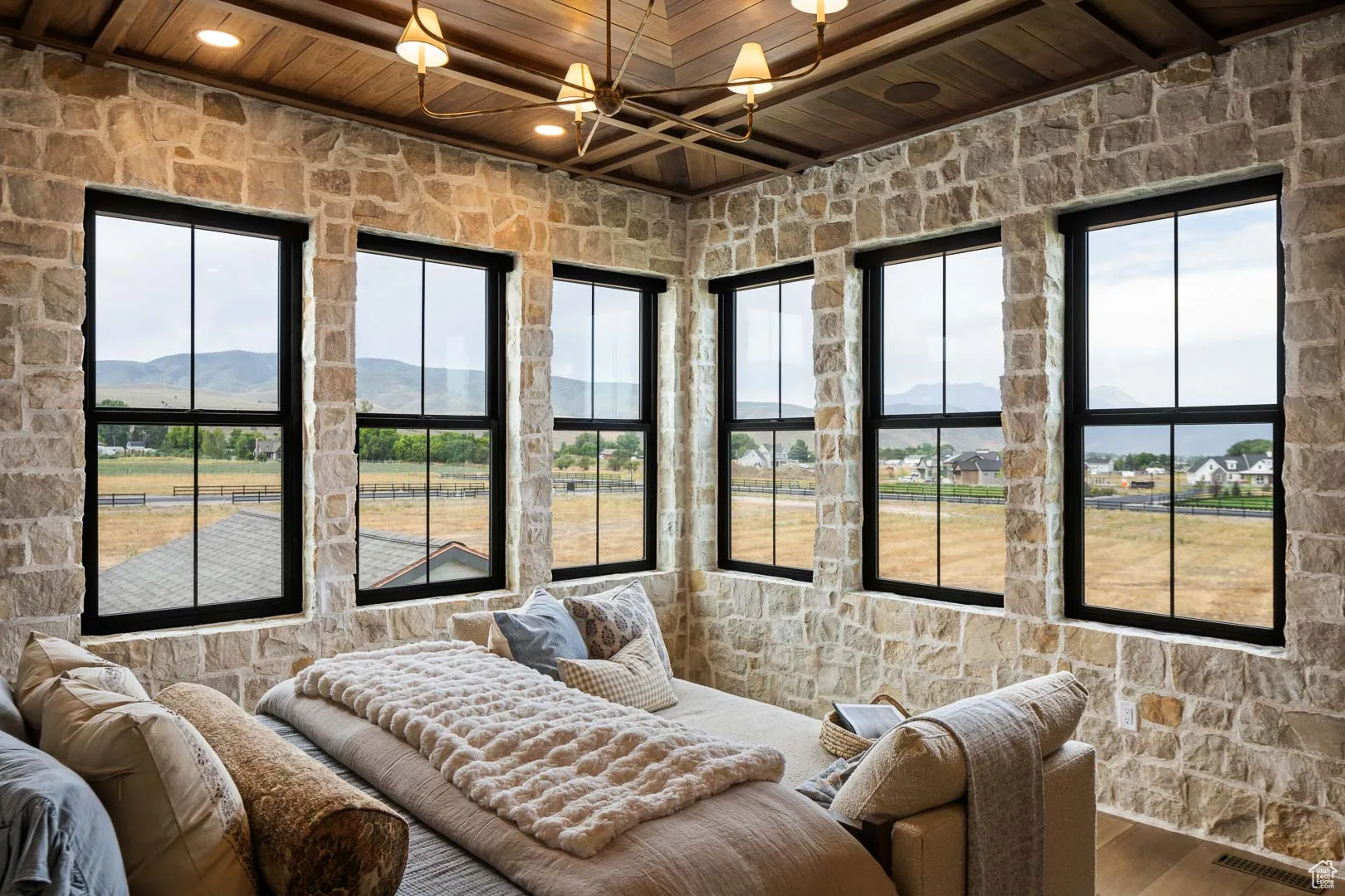 Bedroom featuring a wood ceiling with exposed beams, wood finished floors, and a mountain view