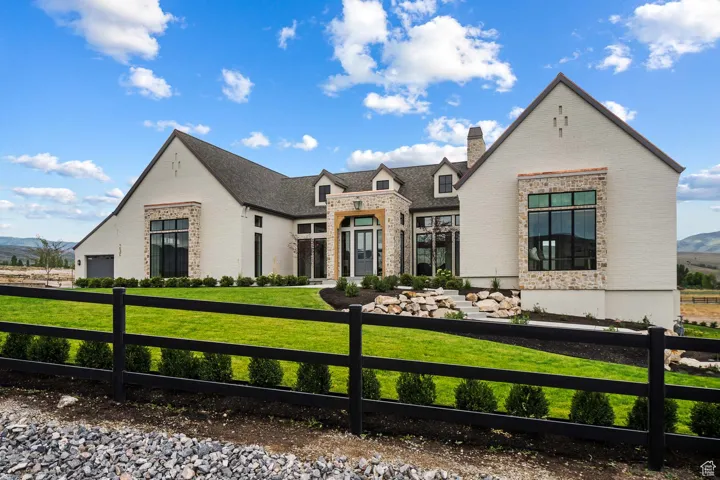 View of front of property featuring a fenced front yard, brick siding, a chimney, a mountain view, and stone siding