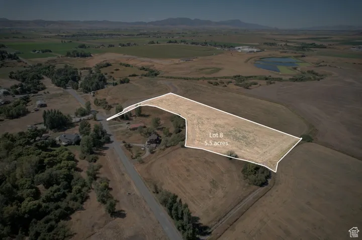 Aerial view of property and surrounding area featuring rural landscape, property boundaries highlighted, and mountains