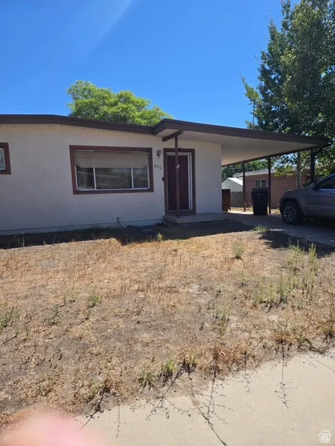 View of front of house featuring an attached carport and stucco siding