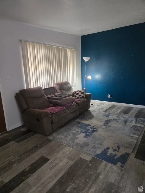 Living room with a textured ceiling and dark wood finished floors