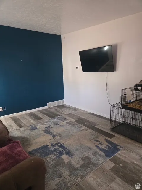 Empty room with dark wood finished floors and a textured ceiling