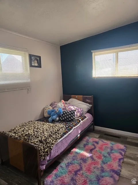Bedroom with dark wood-type flooring and a textured ceiling