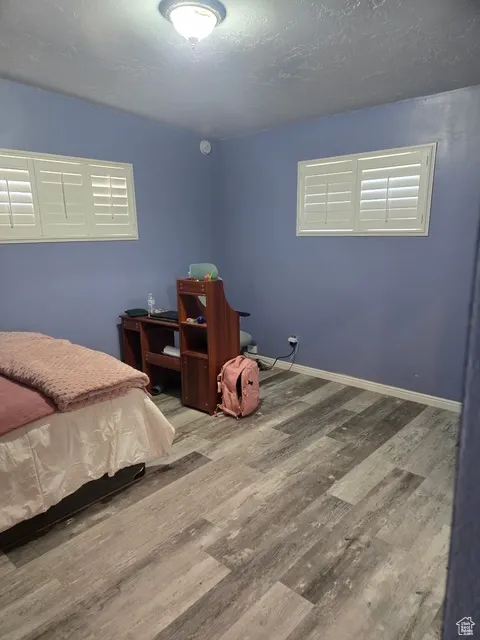 Bedroom with wood finished floors and a textured ceiling