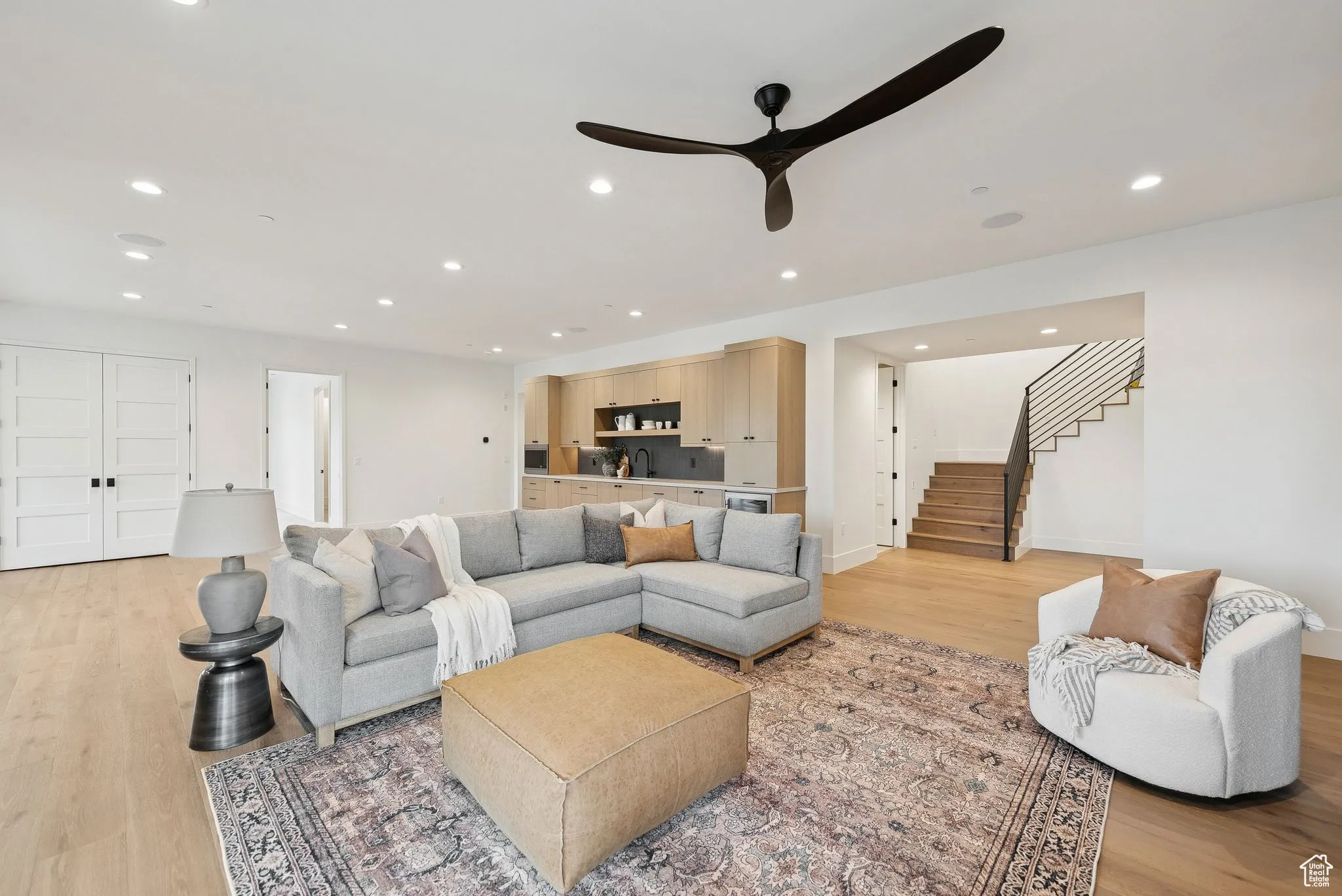 Living area with light wood finished floors, recessed lighting, stairs, and a ceiling fan