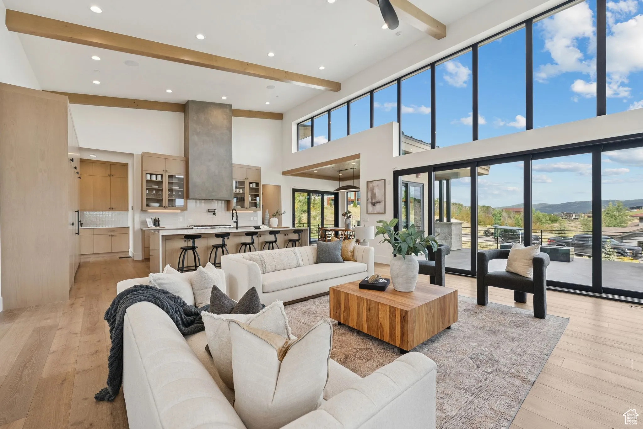 Living room featuring beamed ceiling, light wood-type flooring, recessed lighting, a mountain view, and a high ceiling