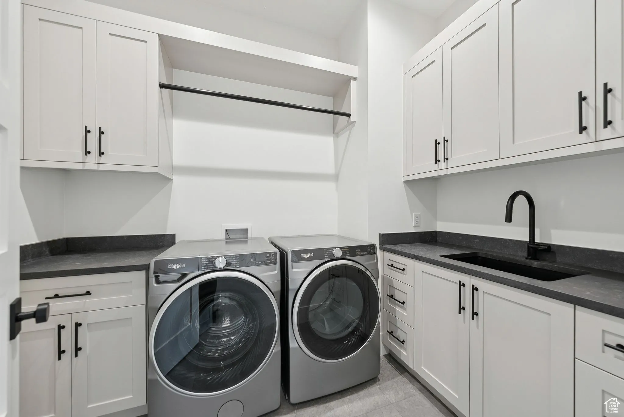 Washroom with washer and clothes dryer and cabinet space