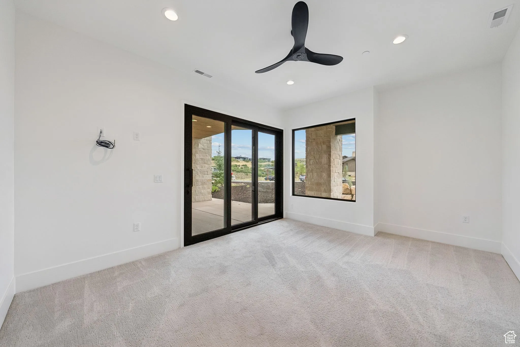 Empty room featuring light colored carpet, recessed lighting, and a ceiling fan
