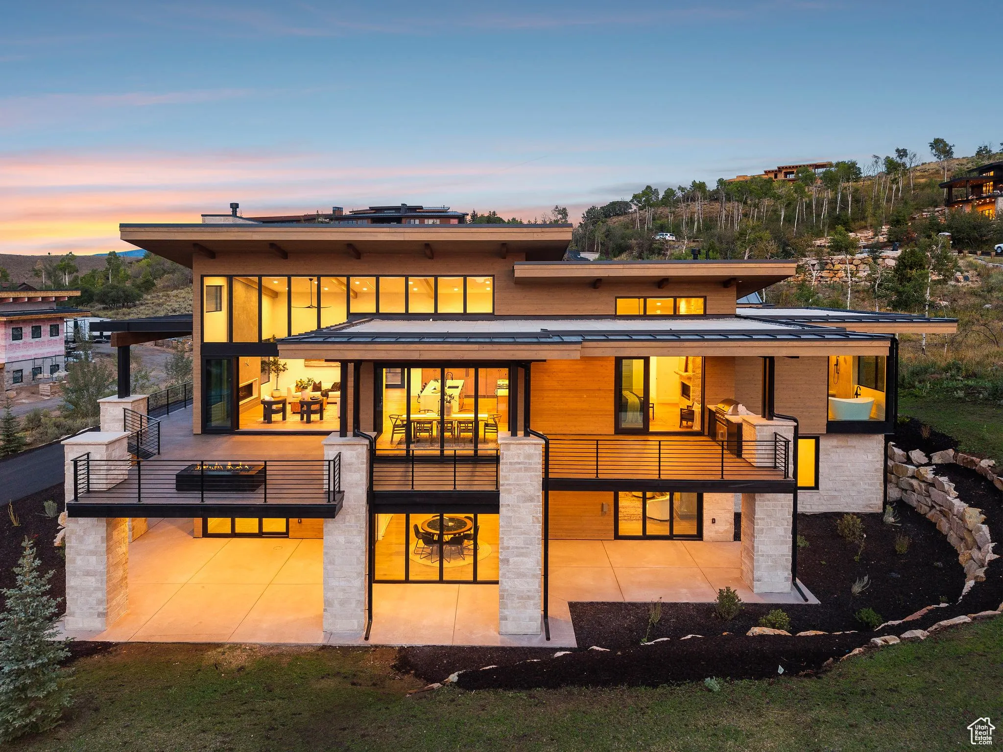 Back of house at dusk featuring a patio, a standing seam roof, and a metal roof