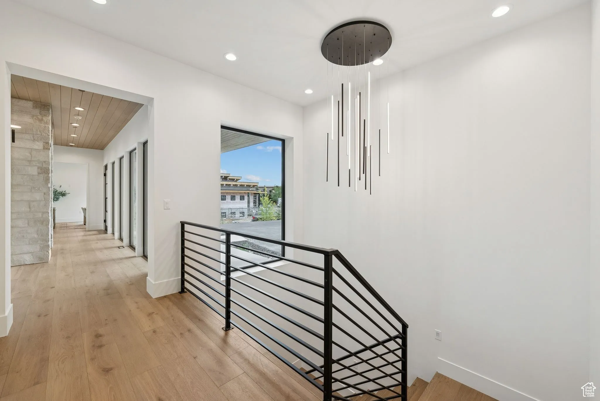 Hall with an upstairs landing, recessed lighting, and light wood-type flooring