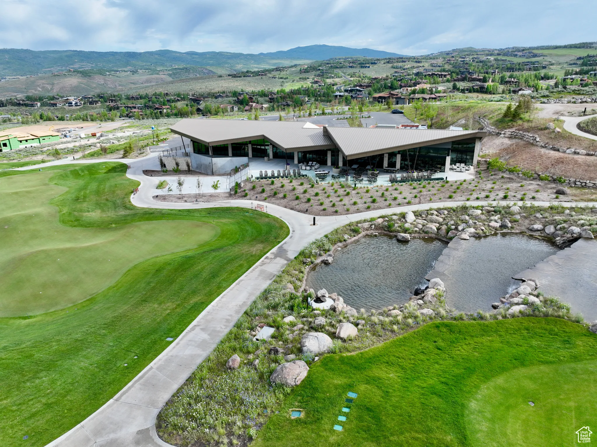 Drone / aerial view of a mountain backdrop and a golf club