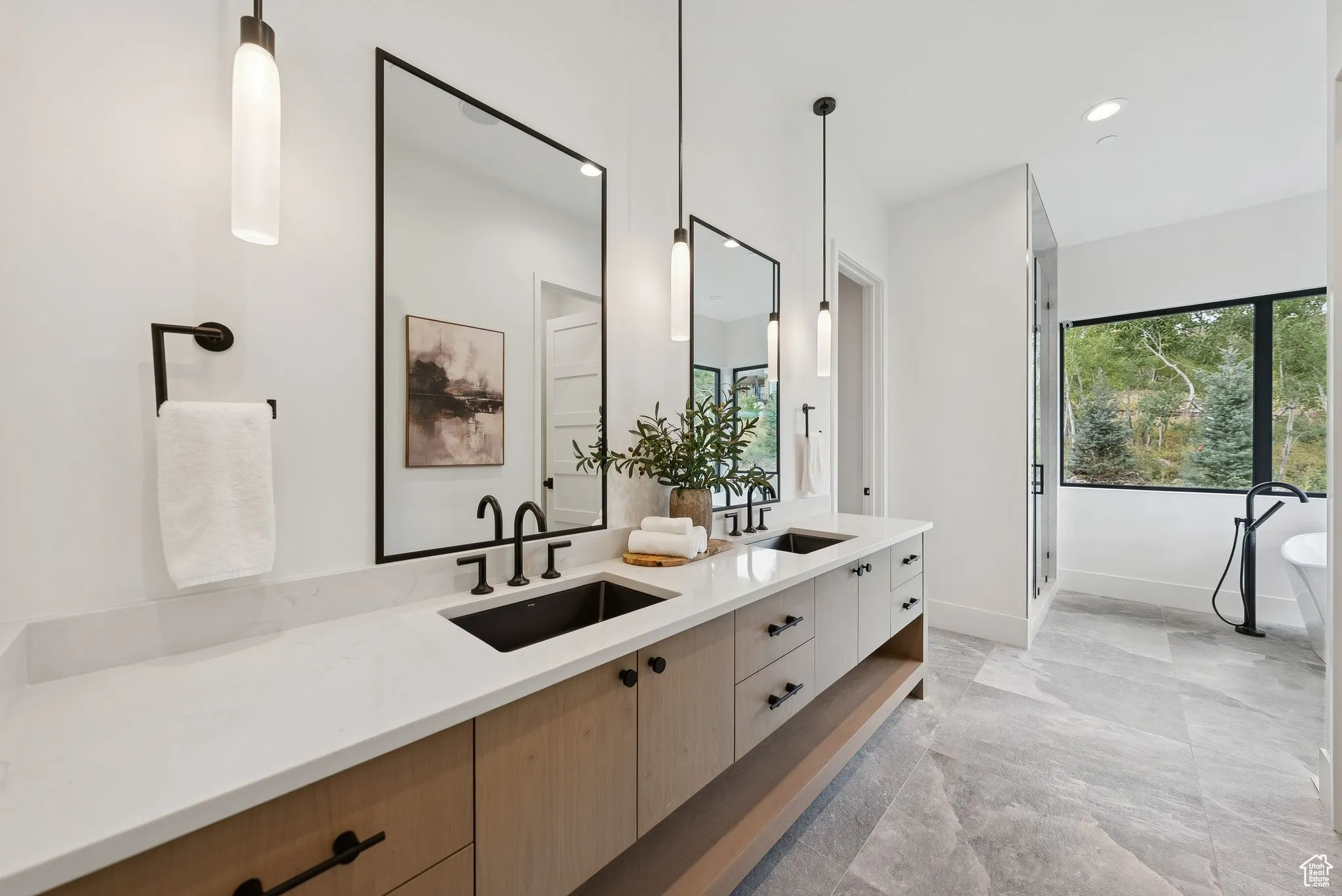 Full bath featuring double vanity, a freestanding bath, a shower stall, and recessed lighting