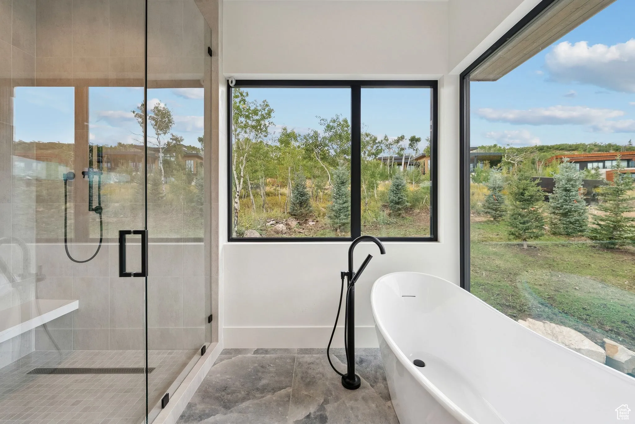 Bathroom featuring healthy amount of natural light, a freestanding tub, and a stall shower
