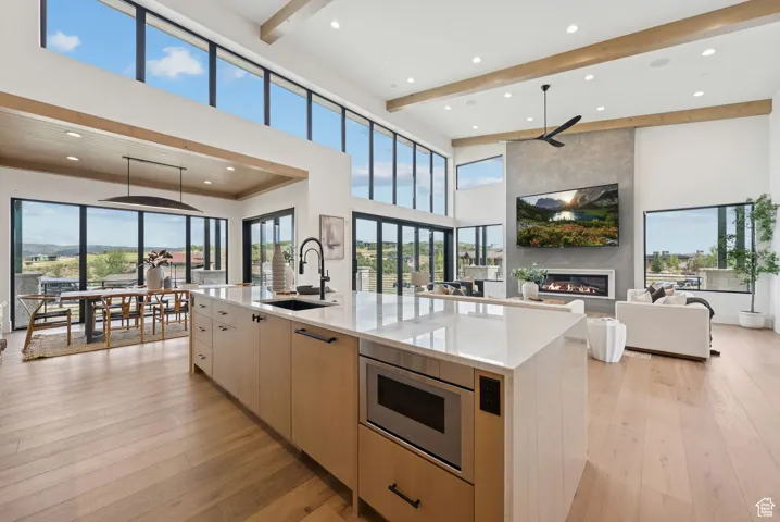 Kitchen with light brown cabinetry, light stone countertops, modern cabinets, light wood finished floors, and recessed lighting