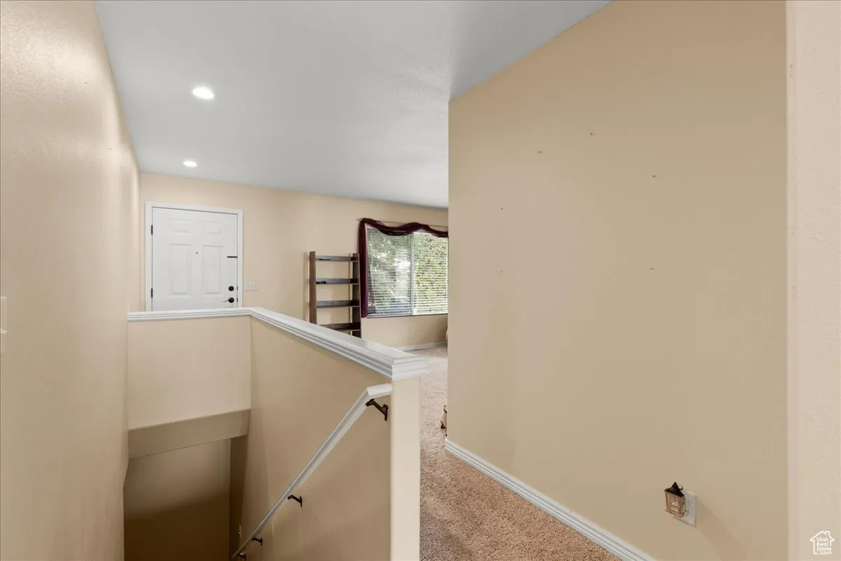 Corridor featuring an upstairs landing, carpet flooring, and recessed lighting