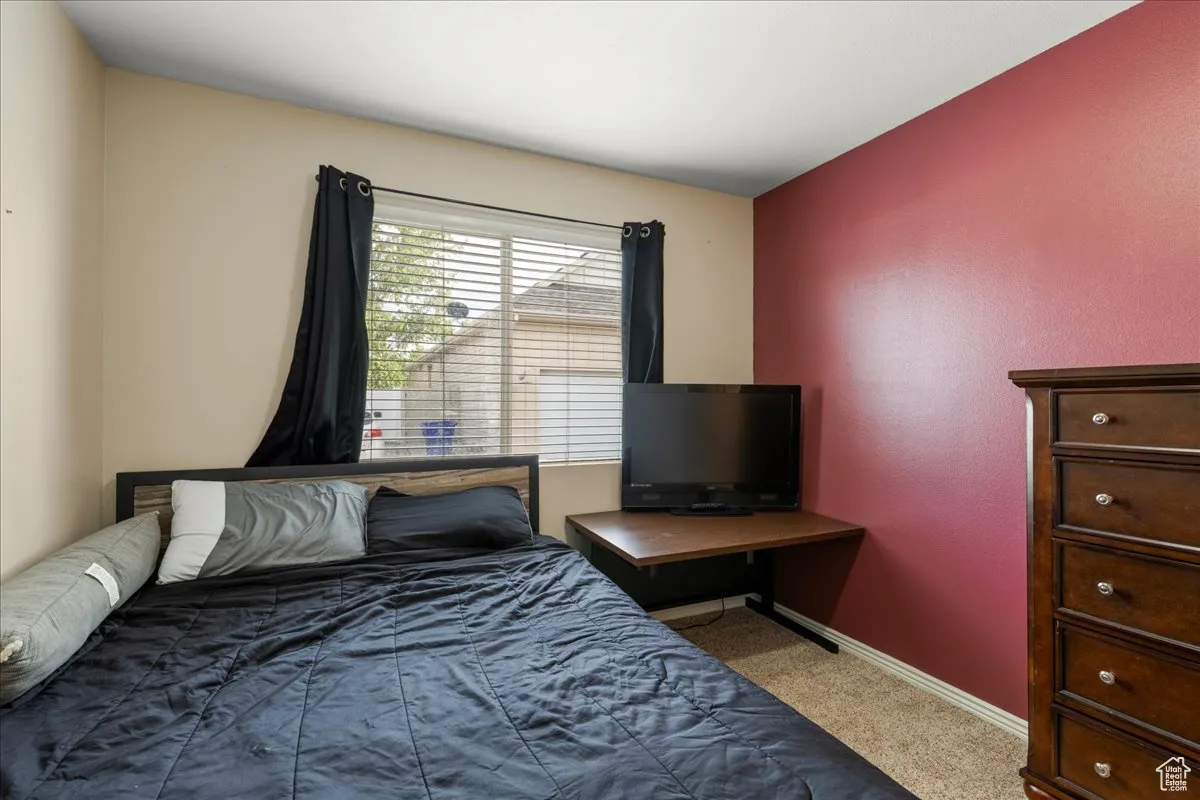 Bedroom featuring carpet and baseboards