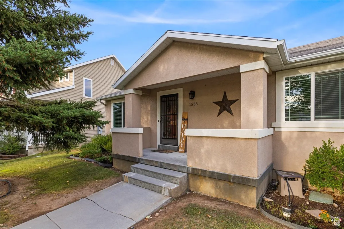 View of front of property featuring stucco siding, a front lawn, and a porch