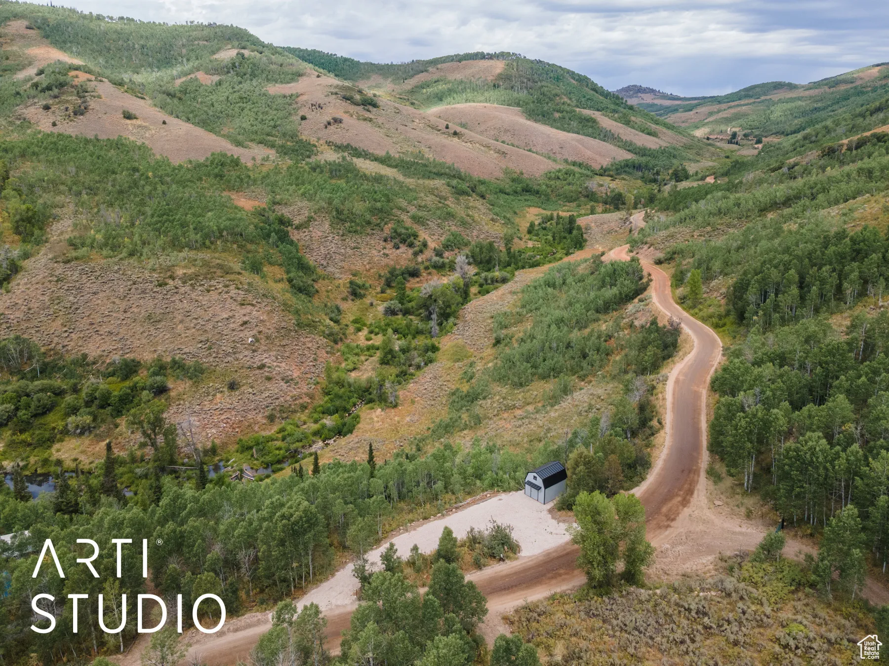 Aerial view of property and surrounding area featuring a mountain backdrop