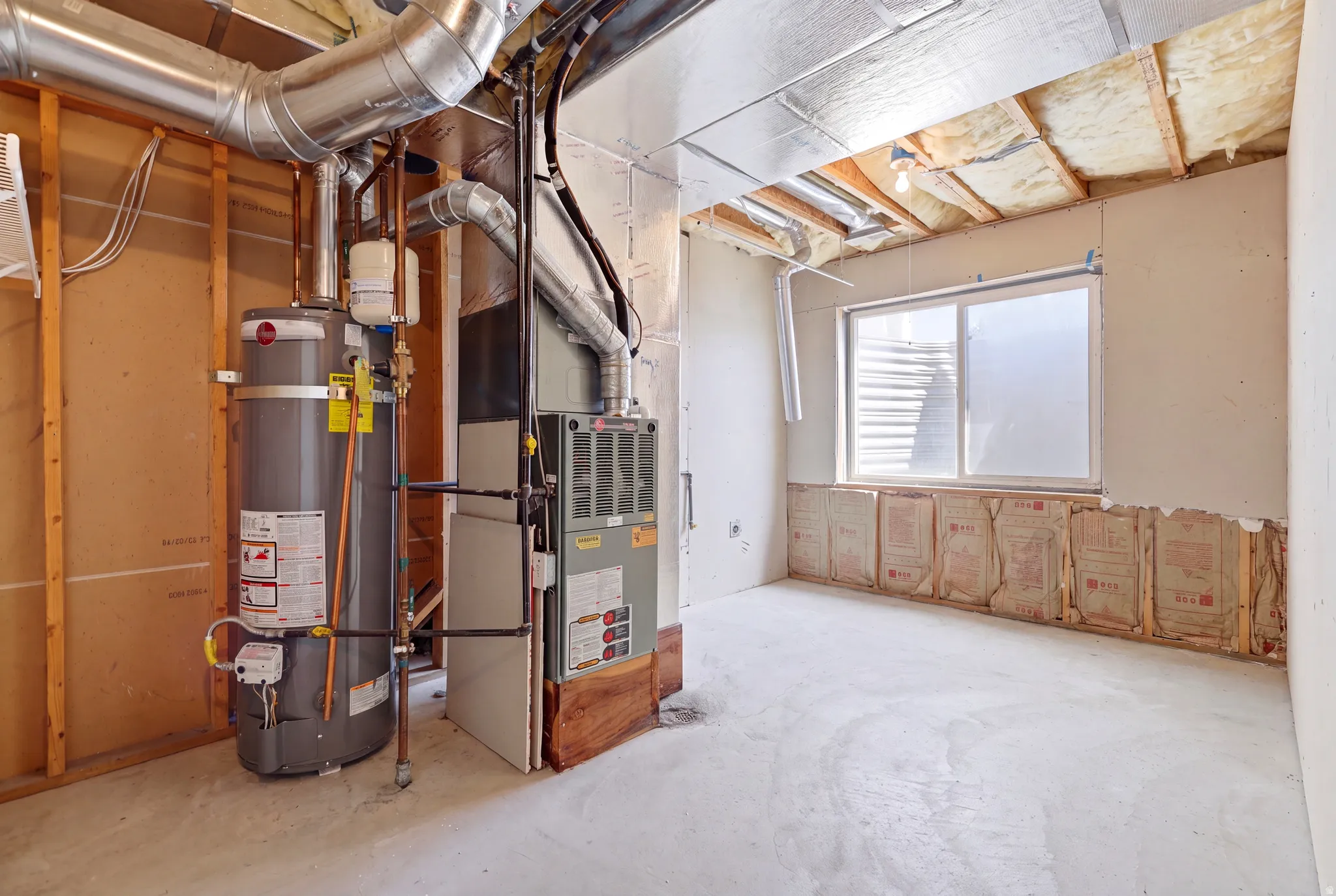 Utility area featuring a water heater, furnace, and exposed ductwork