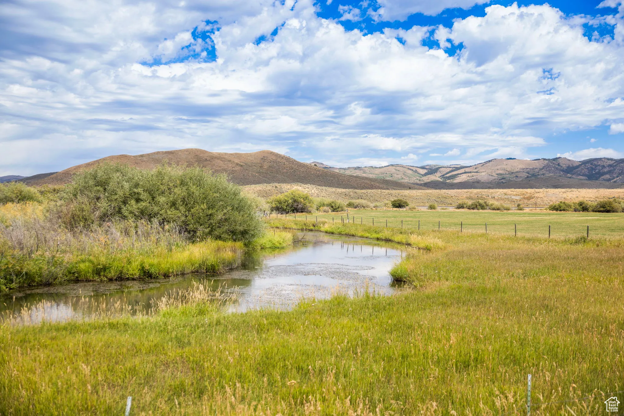 View of mountain background featuring a large body of water and rural landscape