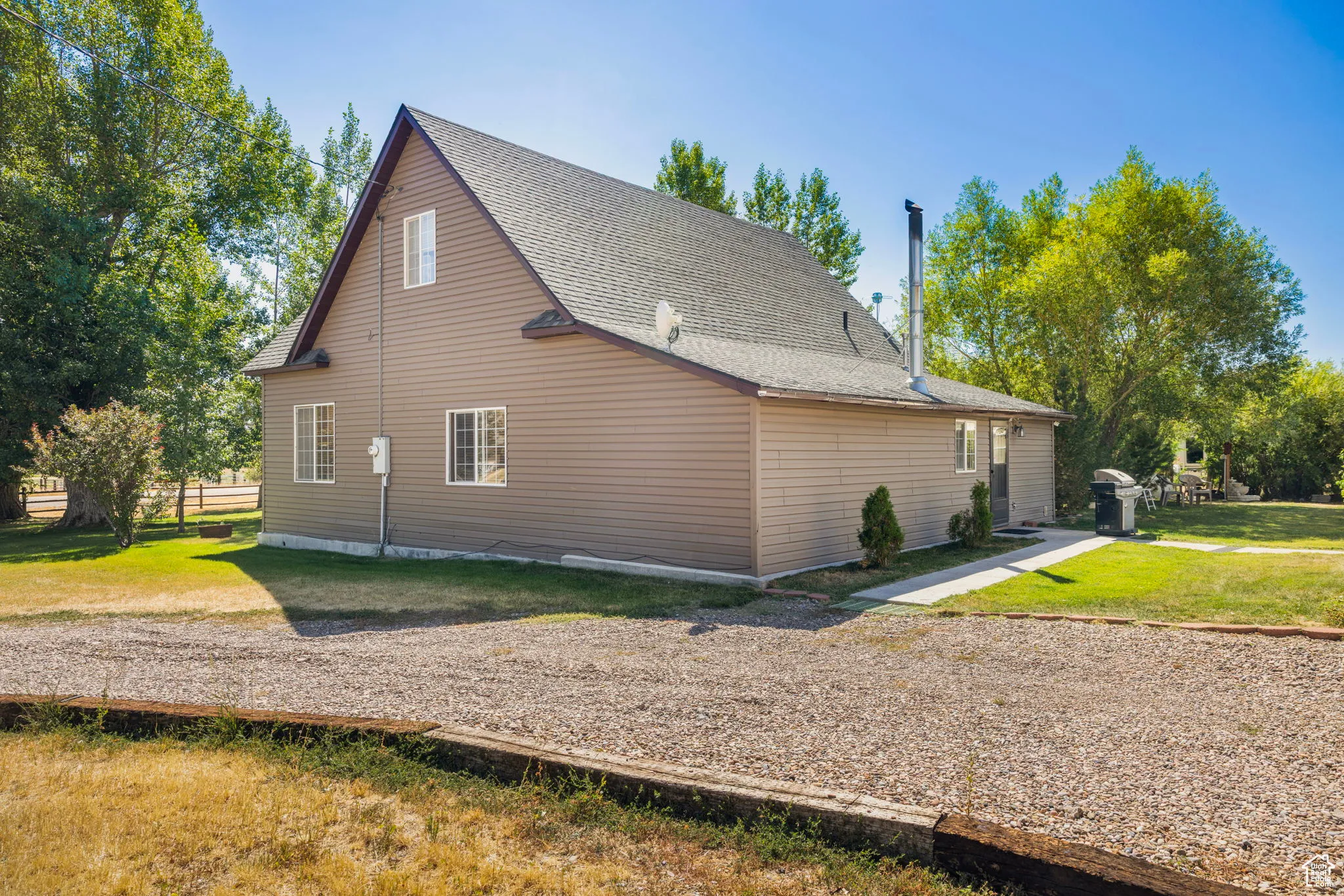View of side of home with a yard and a shingled roof