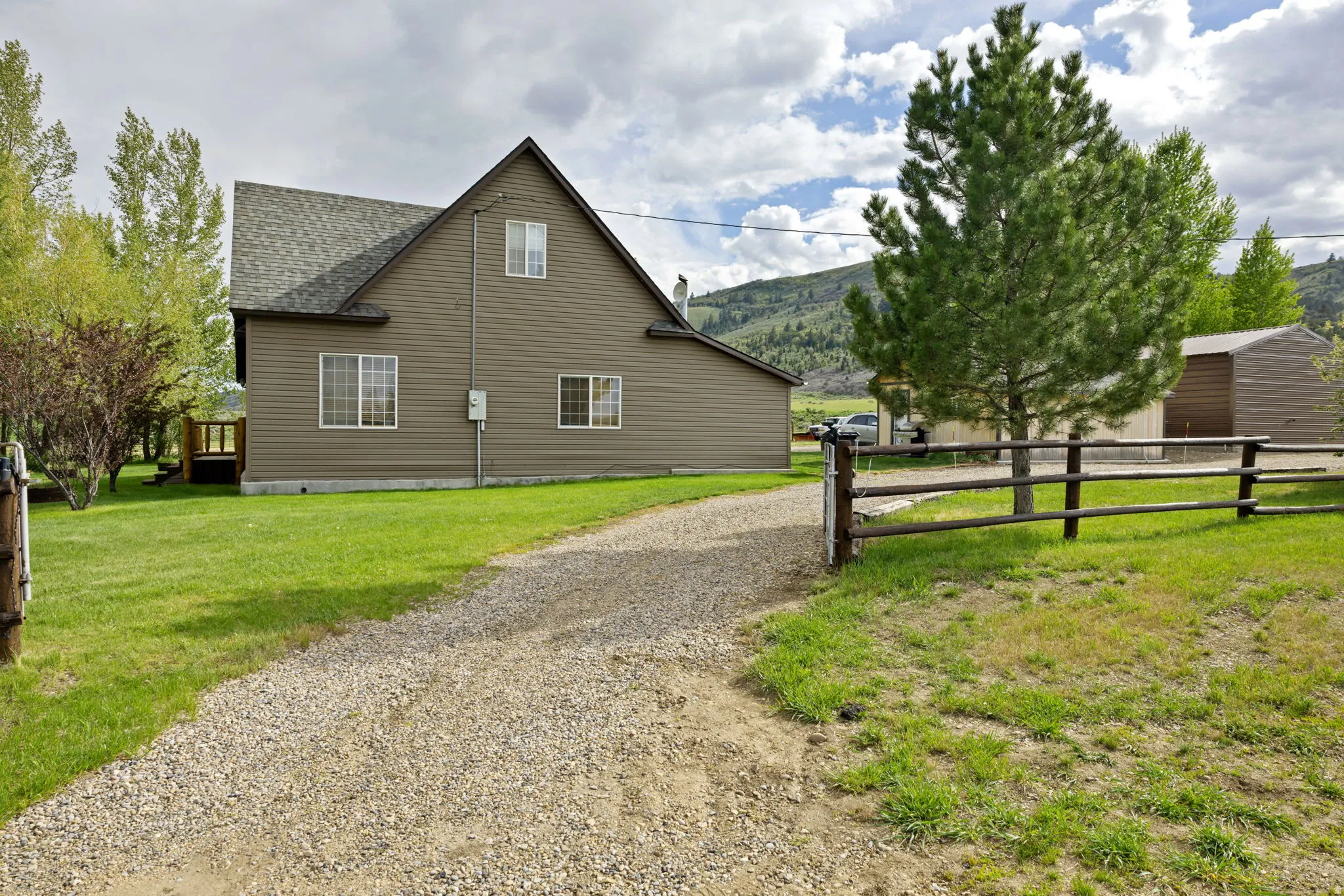 Two-story residence featuring horizontal siding, a gabled roofline, and multiple windows with white trim