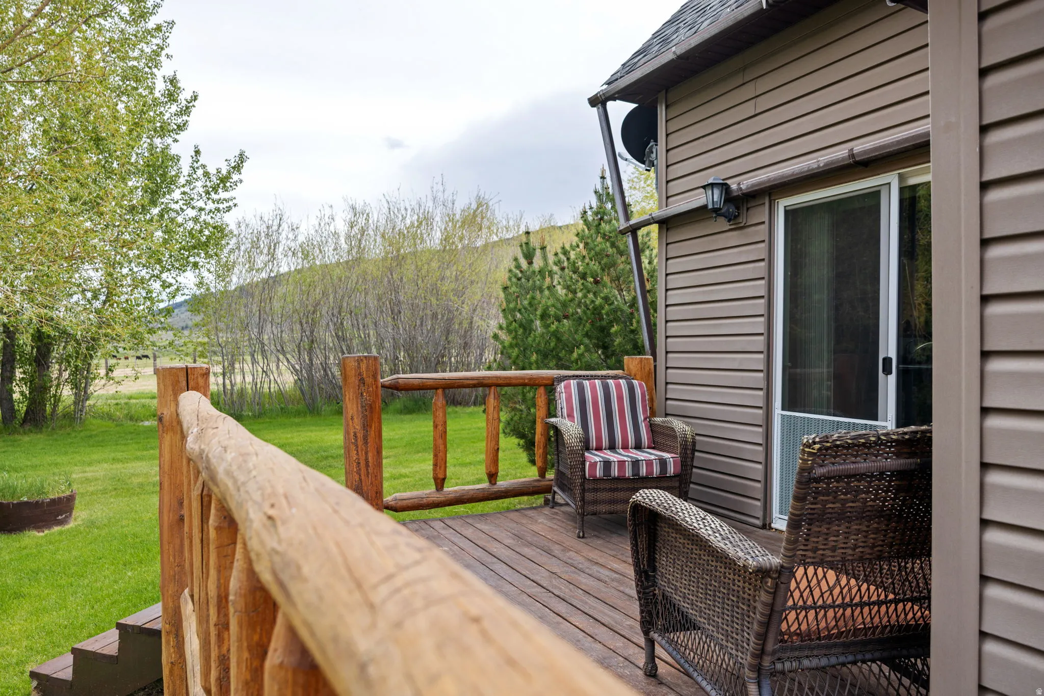 Wood-finish deck featuring rustic log railings and steps