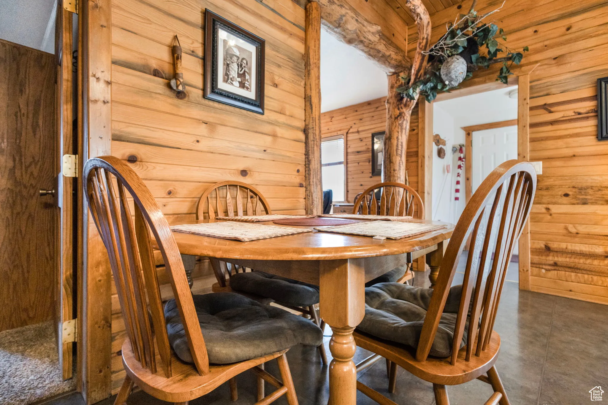 Dining area with wooden walls and beamed ceiling
