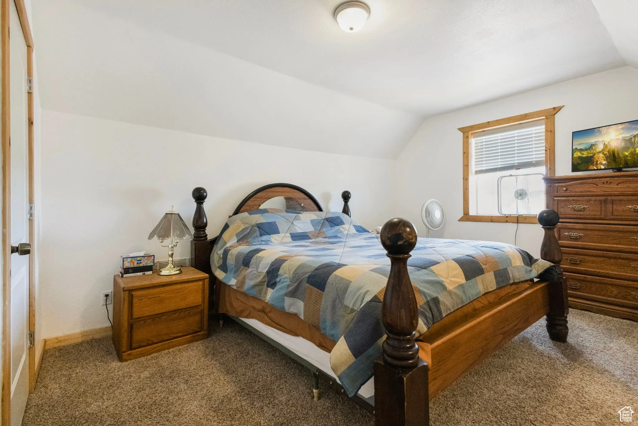 Carpeted bedroom with lofted ceiling and baseboards