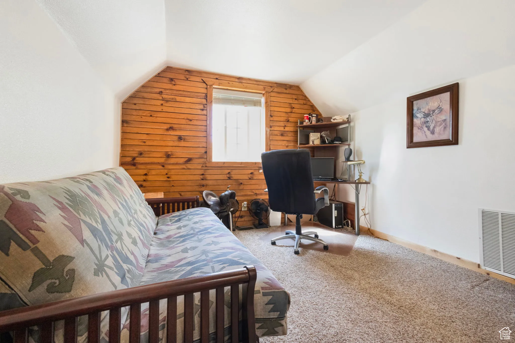 Office area featuring wood walls, vaulted ceiling, and carpet