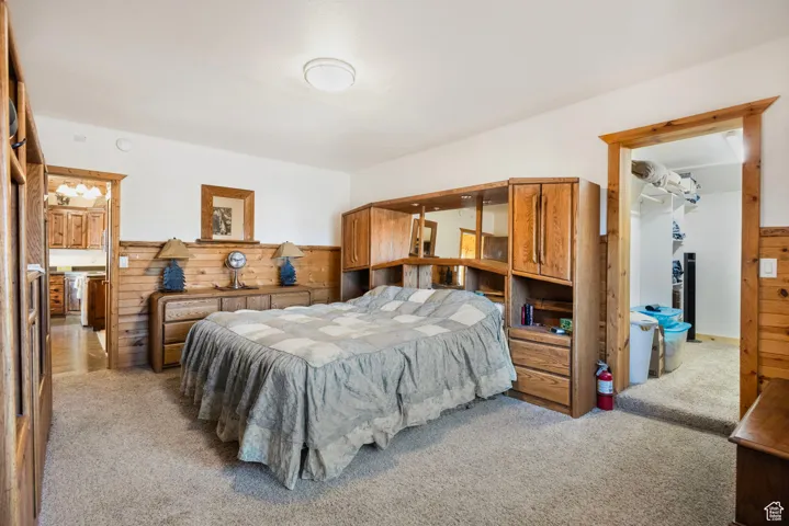 Carpeted bedroom with wood walls
