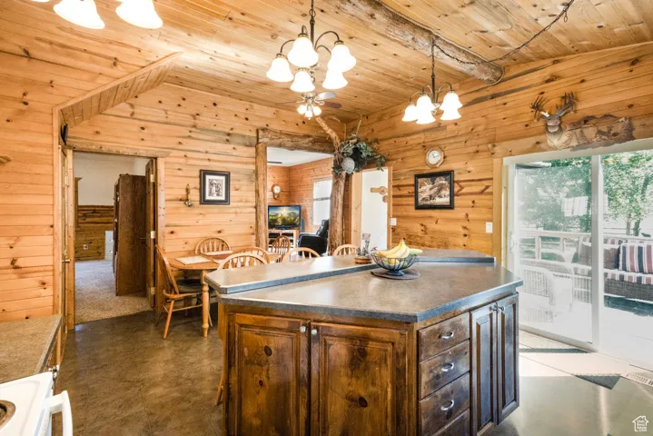 Kitchen featuring decorative light fixtures, wood walls, a kitchen island, white range oven, and wooden ceiling