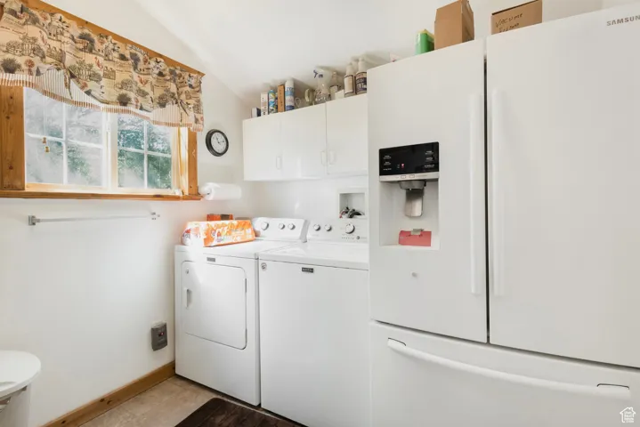 Laundry area with independent washer and dryer and baseboards