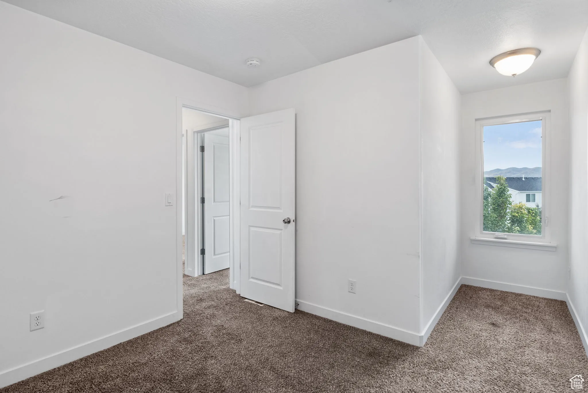 Unfurnished bedroom with baseboards and dark colored carpet