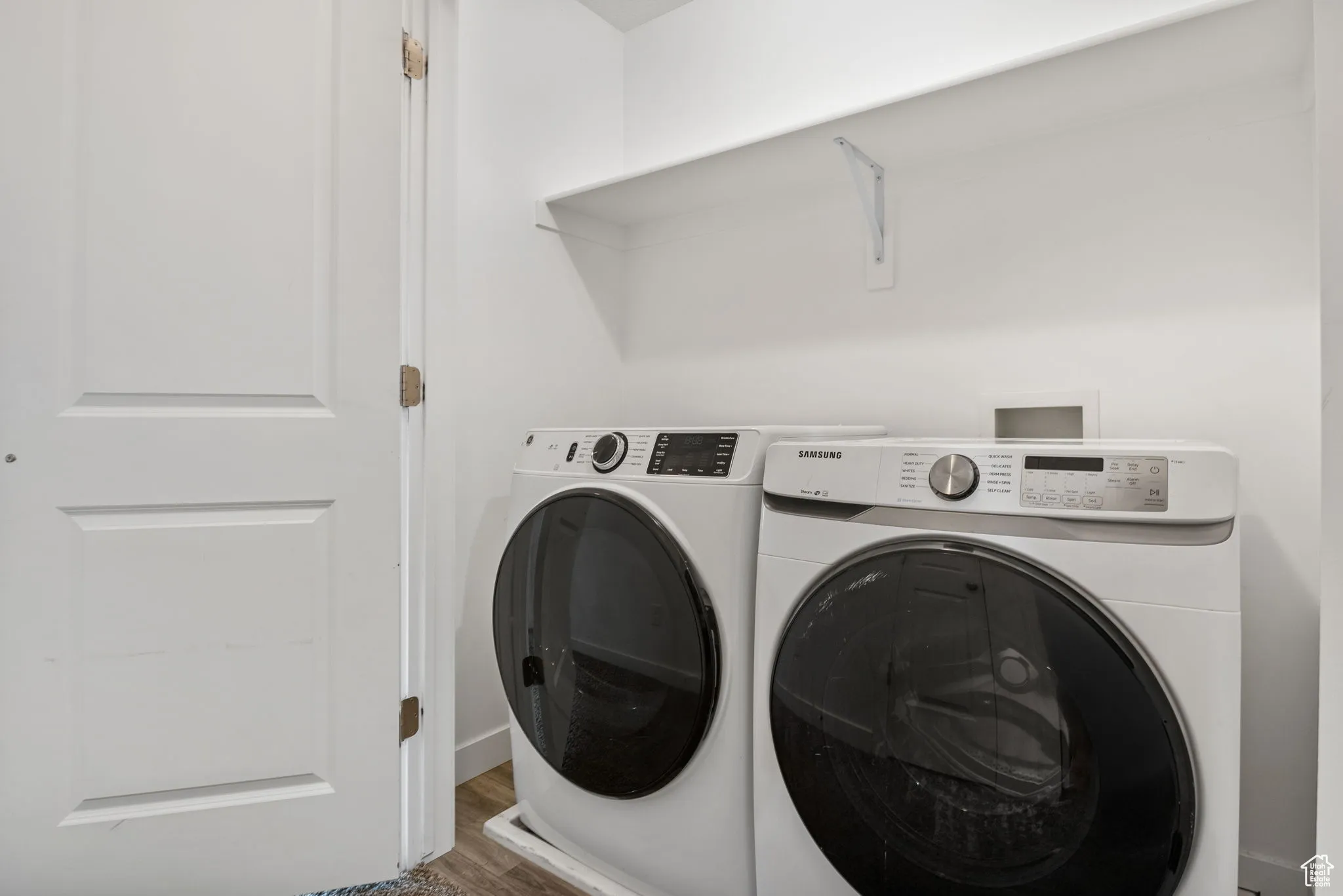 Laundry area featuring washer and clothes dryer and wood finished floors