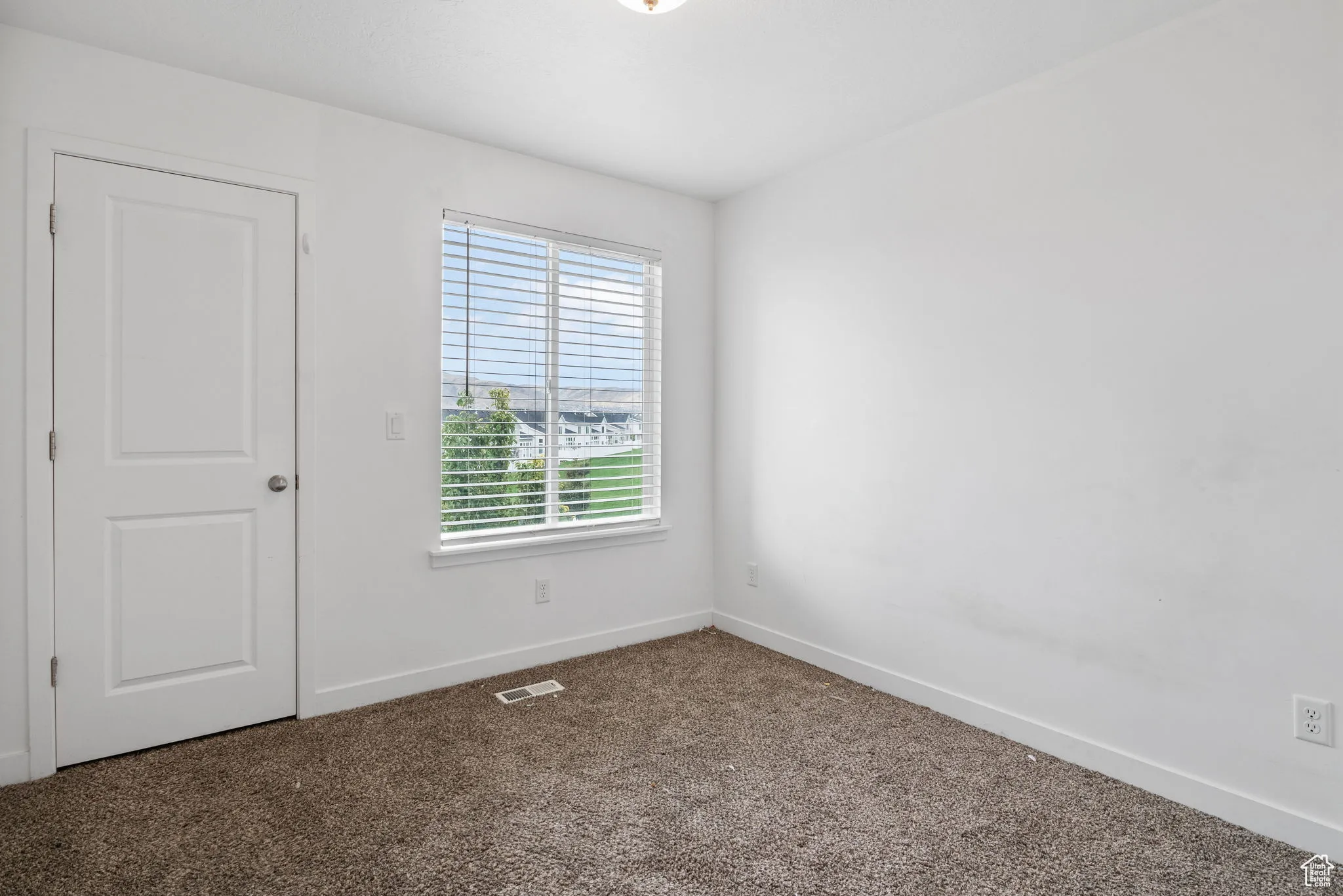 Carpeted empty room featuring baseboards