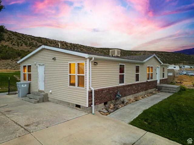 View of front of house featuring, brick siding, a mountain view, entry steps, and a lawn