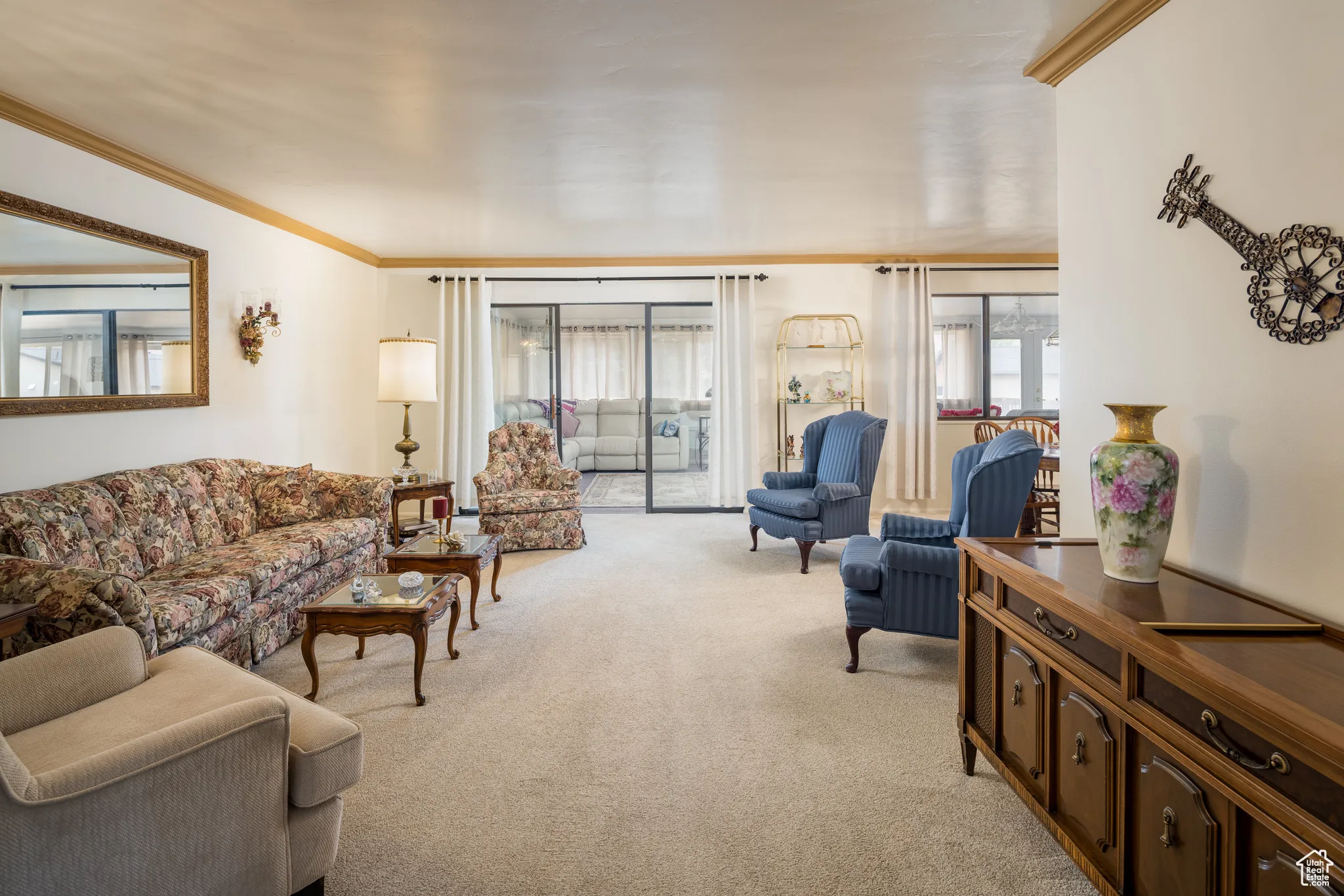 Living area featuring crown molding and light carpet
