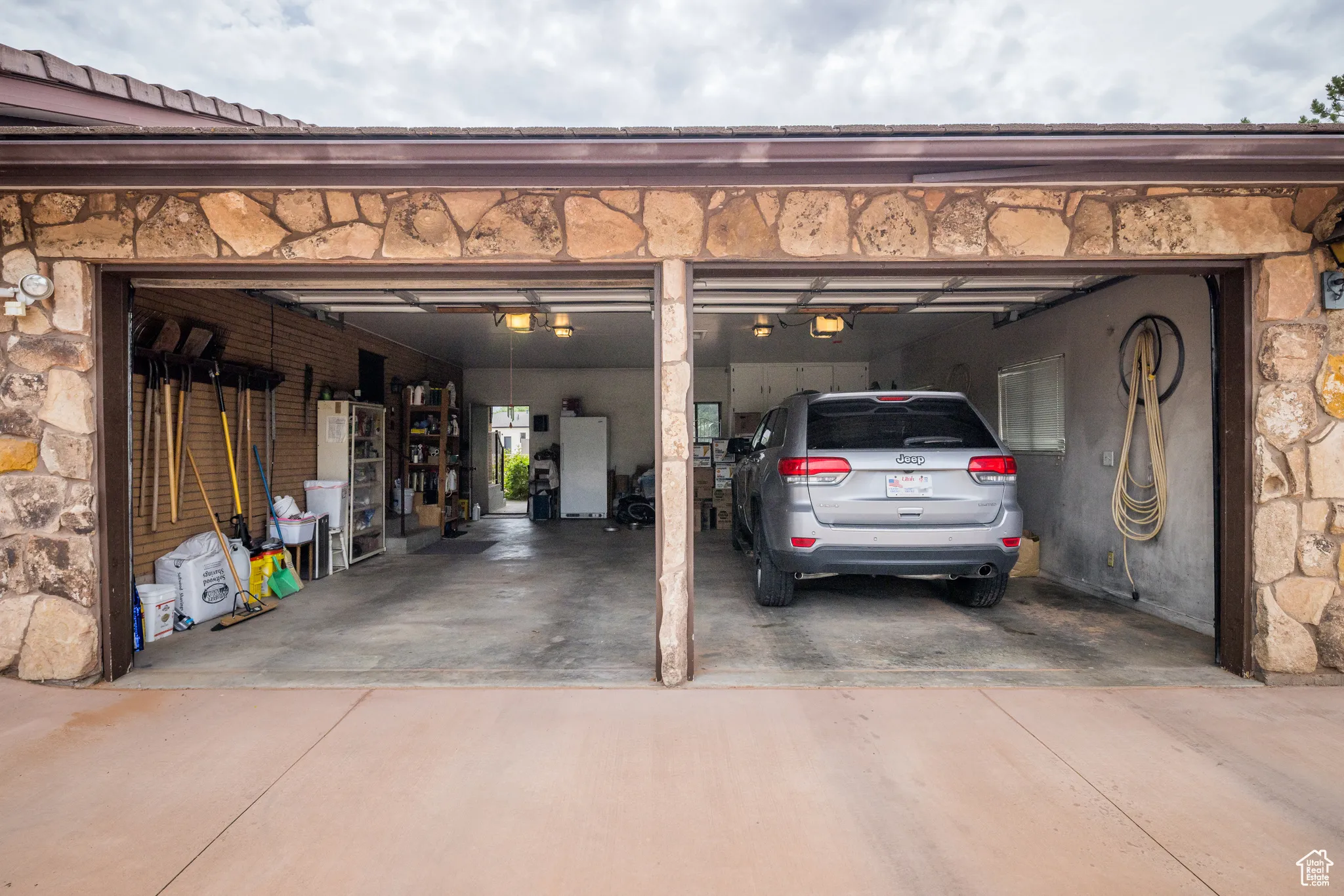 Garage featuring driveway and white fridge