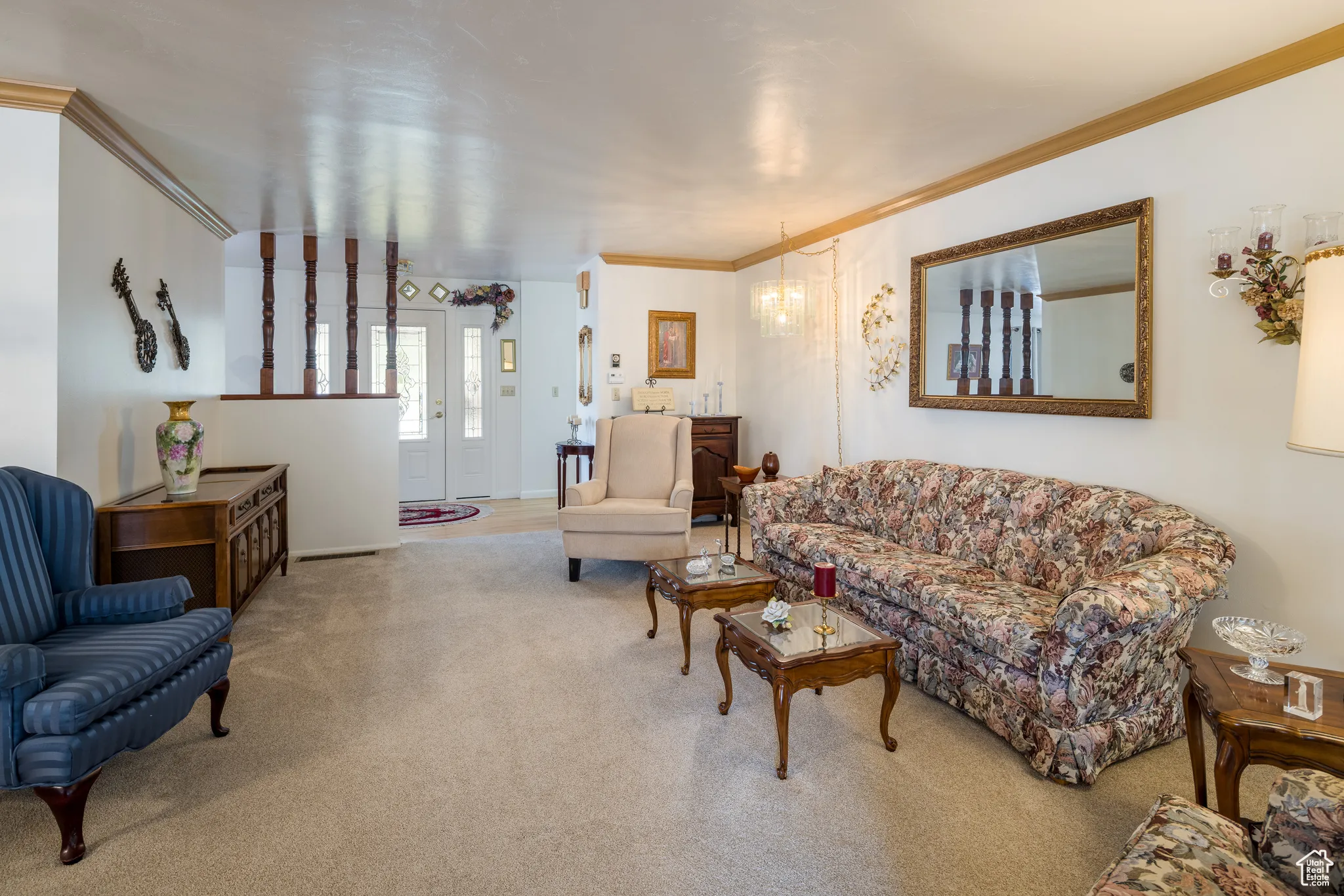 Living room with crown molding, carpet floors, and a chandelier