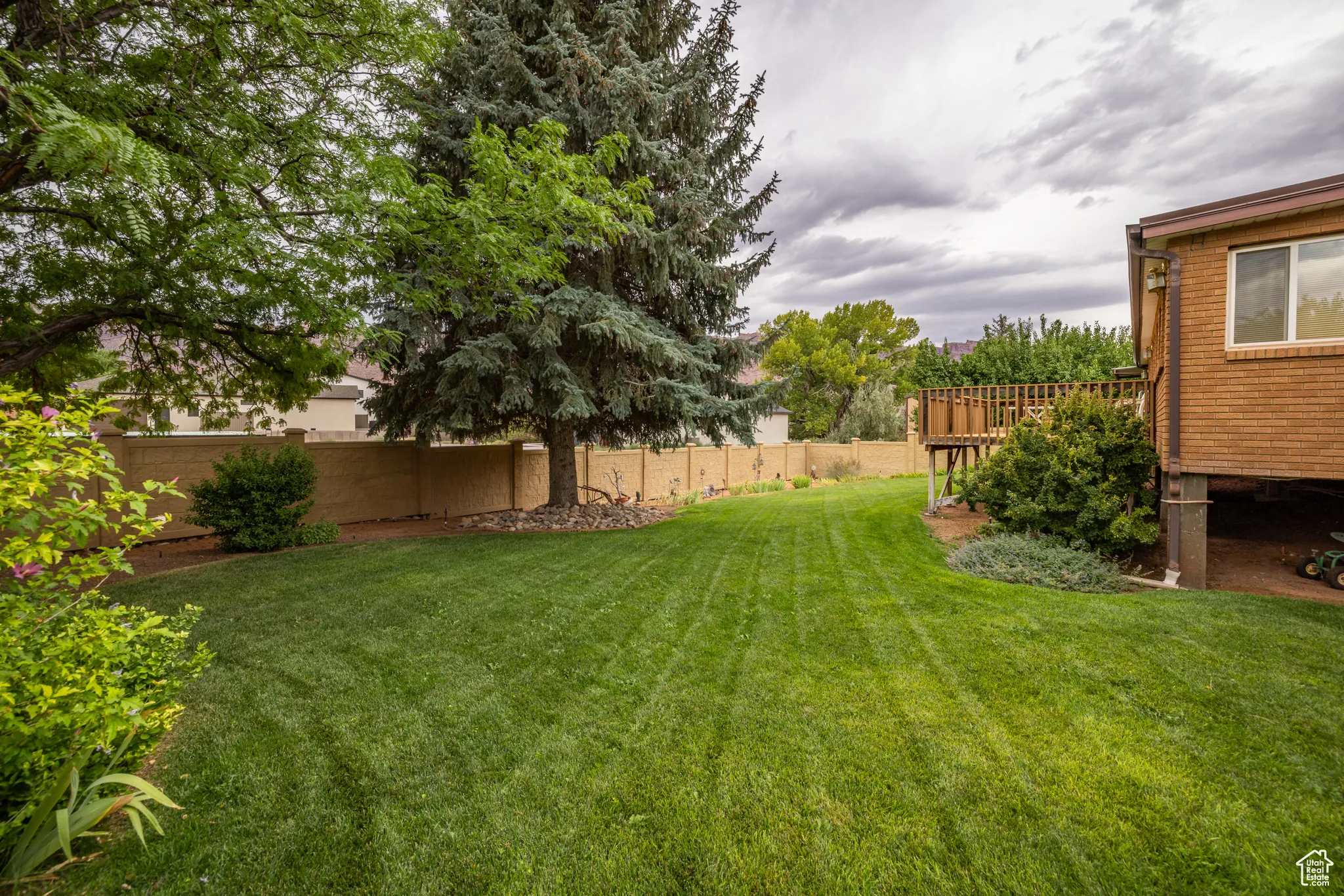 Fenced backyard featuring a deck