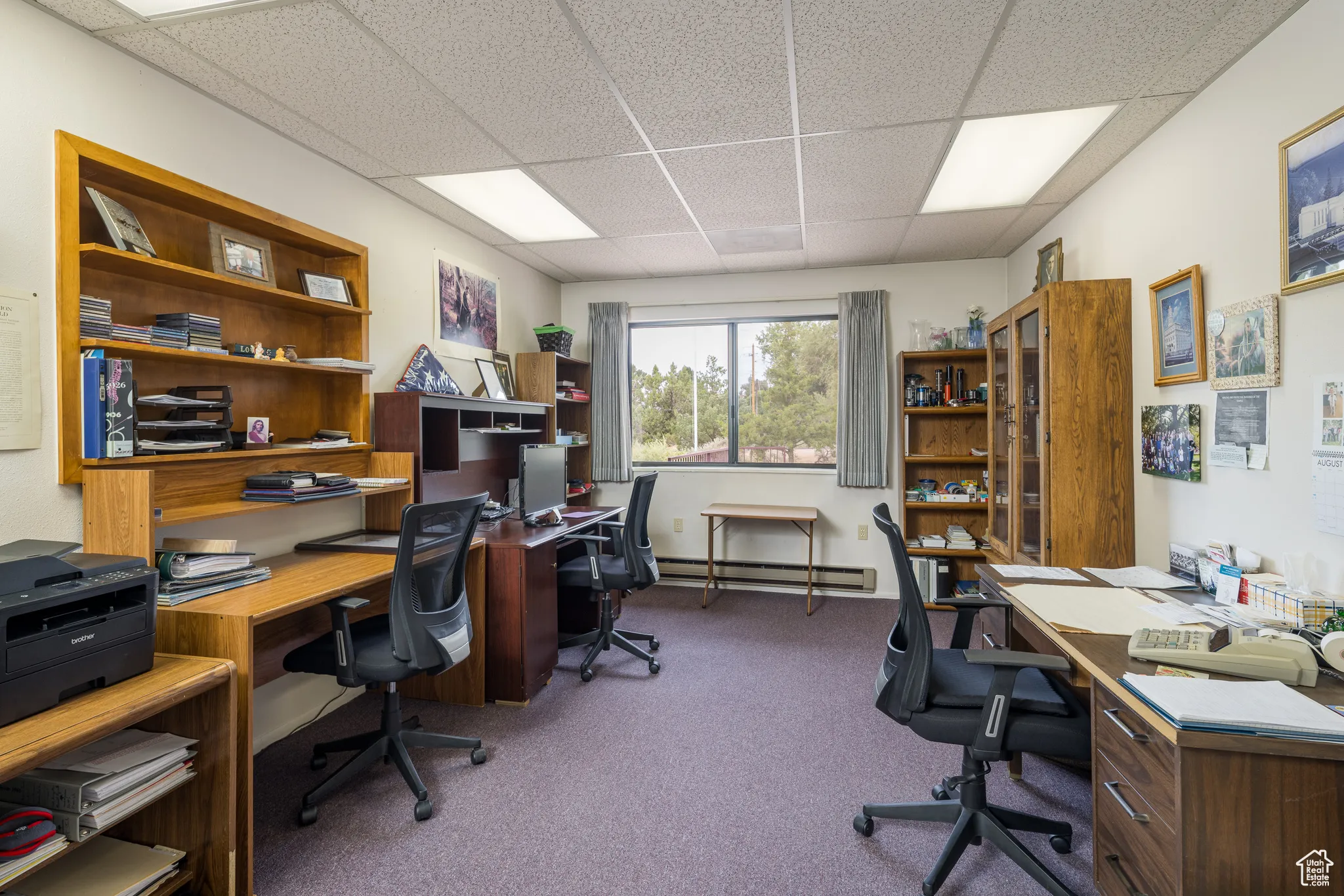 Home office featuring a paneled ceiling, light colored carpet, and a baseboard radiator