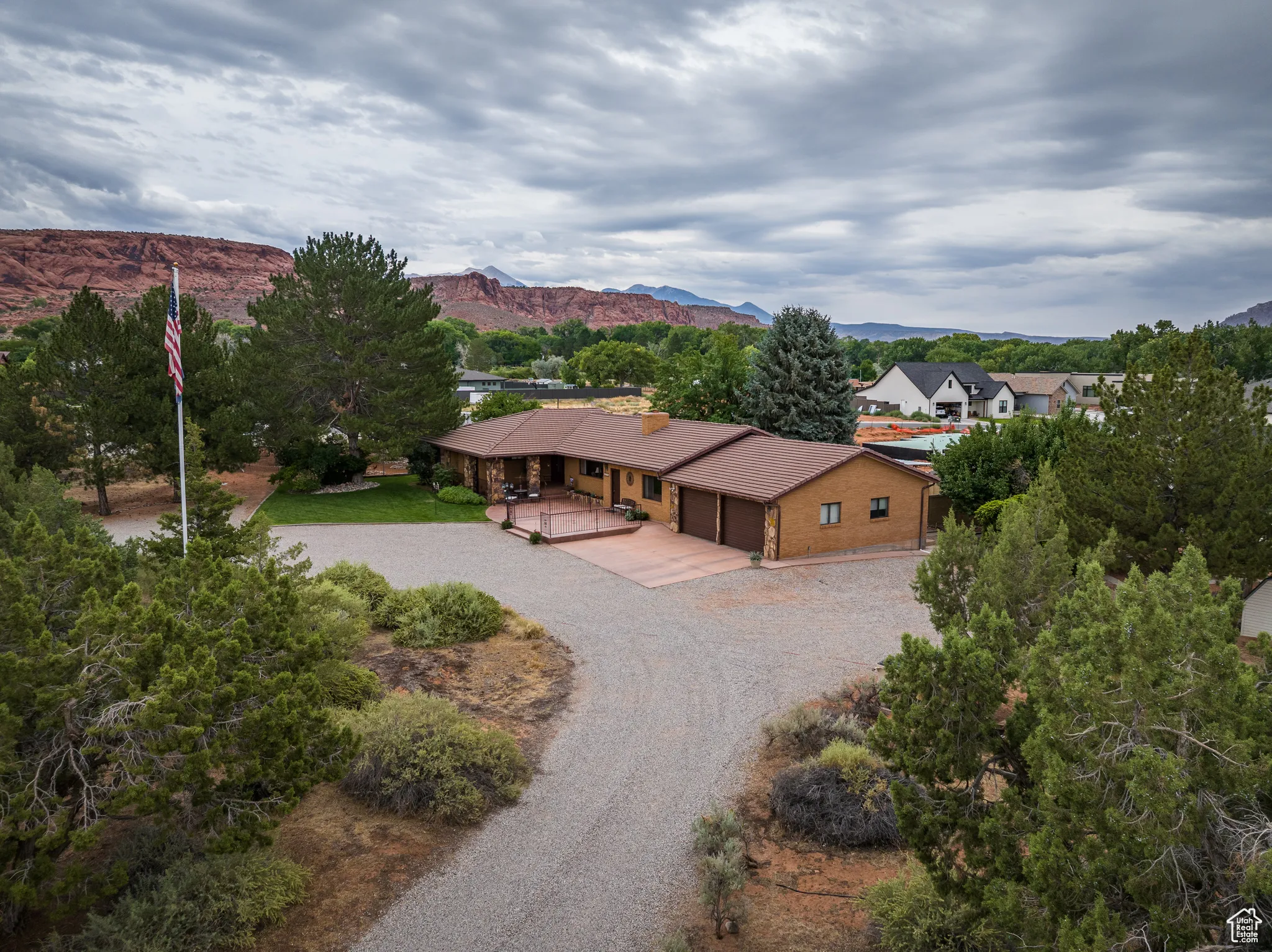 View from above of property with a mountain backdrop and a tree filled landscape