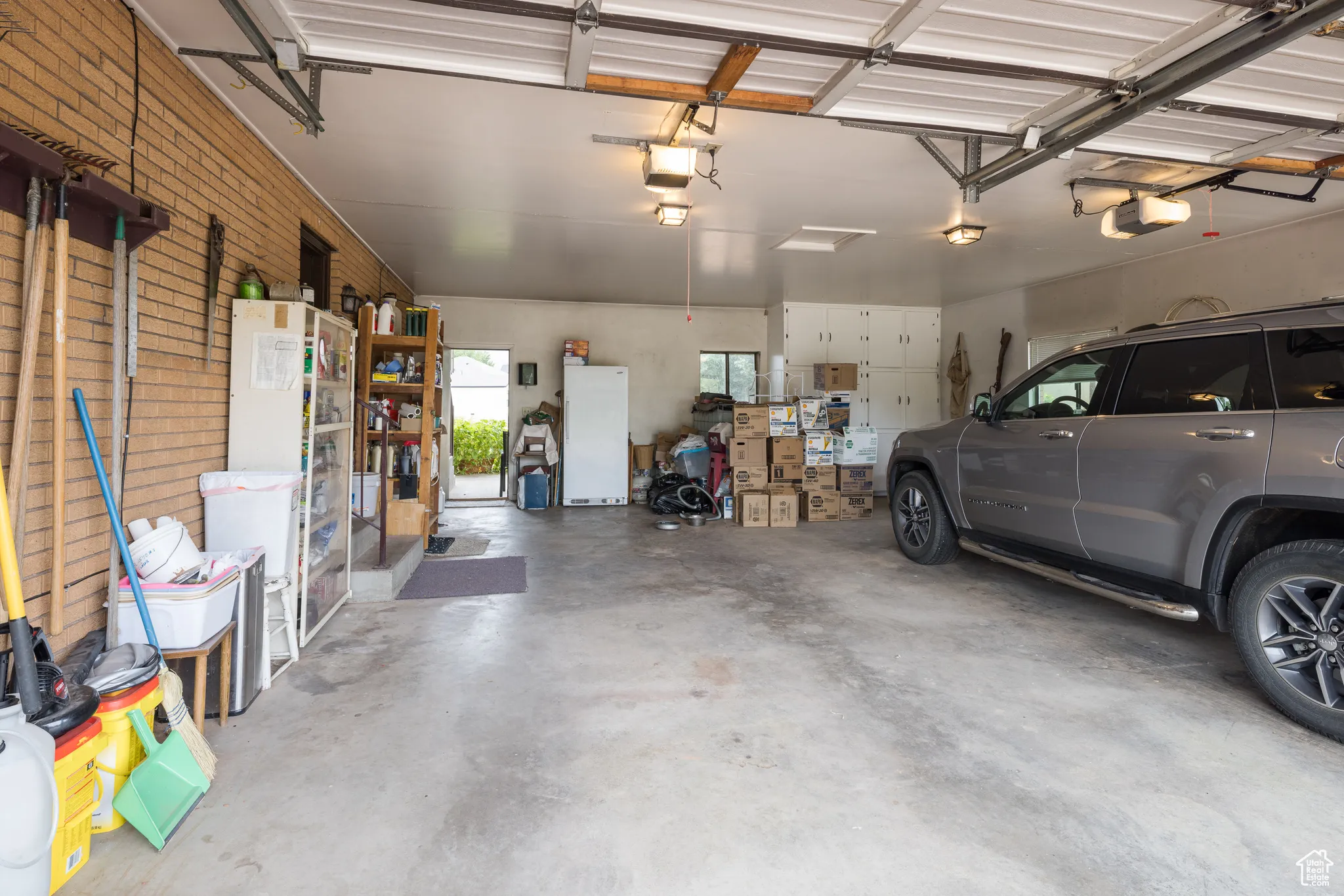 Garage with freestanding refrigerator and a garage door opener