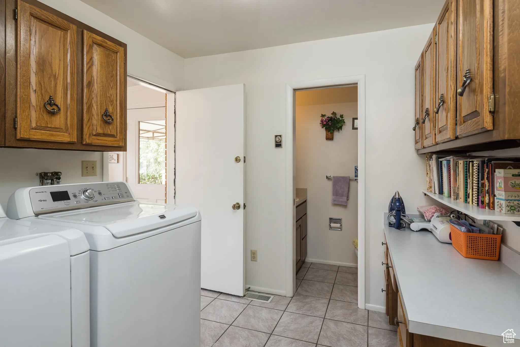 Laundry room featuring cabinet space, washing machine and clothes dryer, and light tile patterned floors