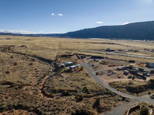 Aerial view of property and surrounding area featuring rural landscape and a mountainous background